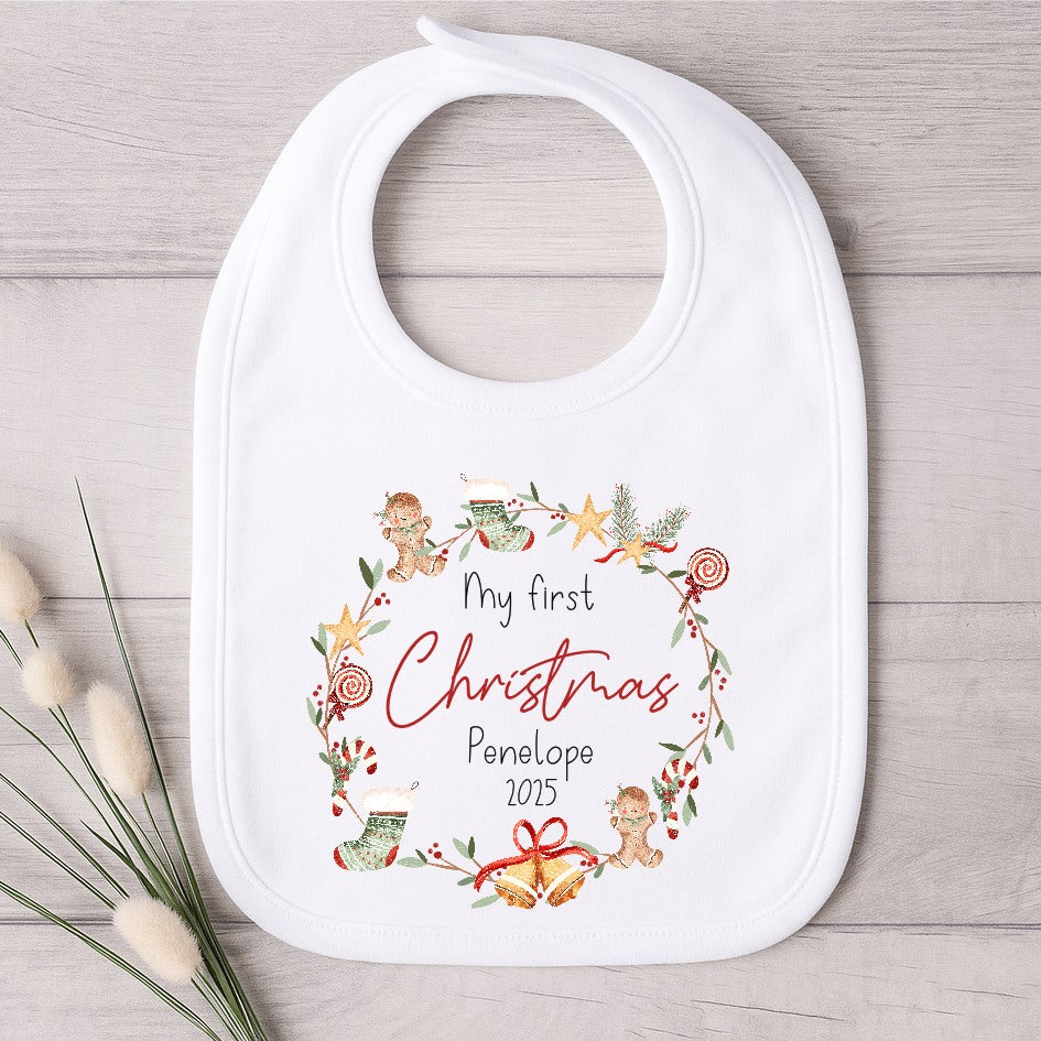 White baby bib with Christmas design and text on a wooden surface